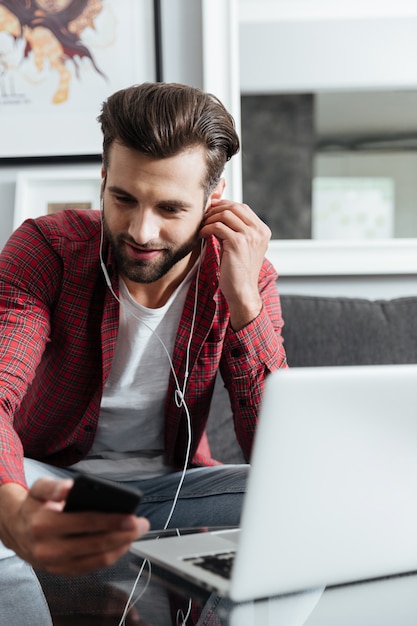 Poważny mężczyzna używa telefonu obsiadanie na leżance