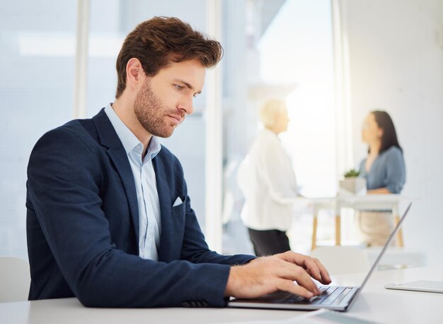 Poważny myślący i biznesowy mężczyzna pracujący na laptopie w biurze z danymi strony internetowej i planowaniem Pracownik zarządzający przedsiębiorcą i analityk baz danych online piszący na komputerze w celu aktualizacji sieci