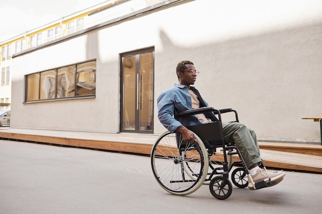Poważny niepełnosprawny mężczyzna na wózku inwalidzkim