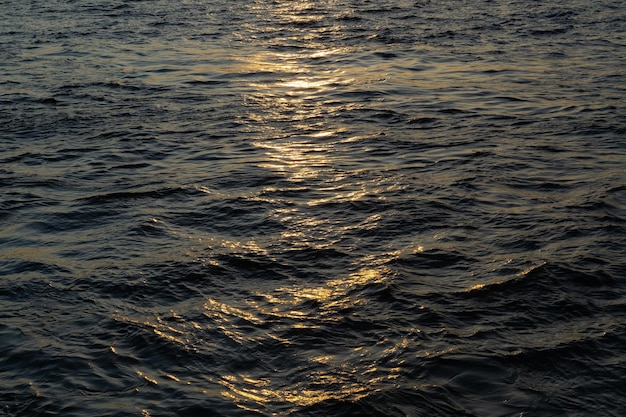 powierzchnia wody rzeki lub jeziora z blaskiem słońca przy zachodzie słońca