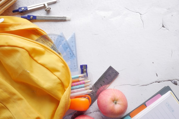 Powrót do koncepcji szkoły z żółtym plecakiem i szkolnymi dostawcami na stole
