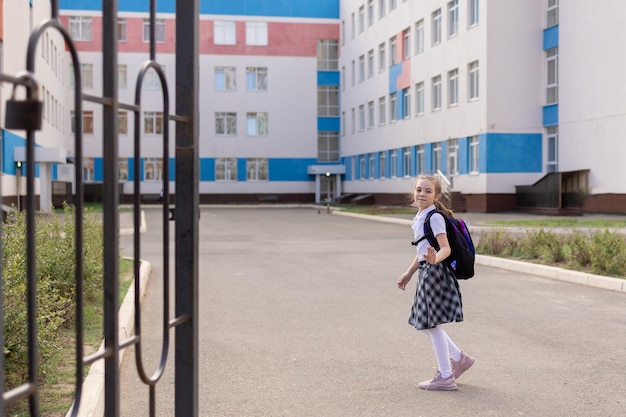 Powrót do szkoły dziewczyna w szkolnym mundurku iść do szkoły