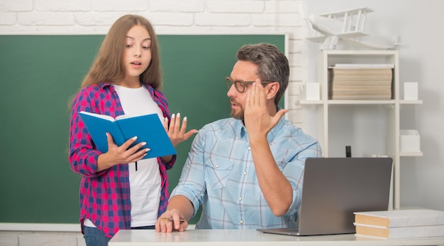 Powrót do szkoły. Edukacja dziecięca. student i nauczyciel z laptopem. ojciec i nastolatka studiują. prywatny nauczyciel i dziecko posiadają zeszyt. pomoc rodzinna. tata i córka używają notebooka.