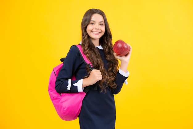 Powrót do szkoły Nastolatka uczennica z plecakiem trzyma jabłko gotowa do nauki Dzieci w wieku szkolnym