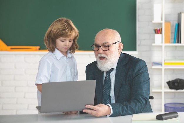 Powrót do szkoły Nauczyciel i dziecko z laptopem Koncepcja edukacji i uczenia się online Uczeń w klasie