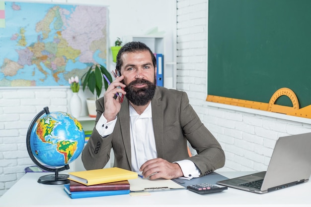 Powrót do szkoły szczęśliwy dzień nauczyciela brutalny mężczyzna z brodą nosi kostium nieformalnej edukacji uczeń siedzi w klasie, podczas gdy lekcja zdaje egzamin ucząc się przedmiotu