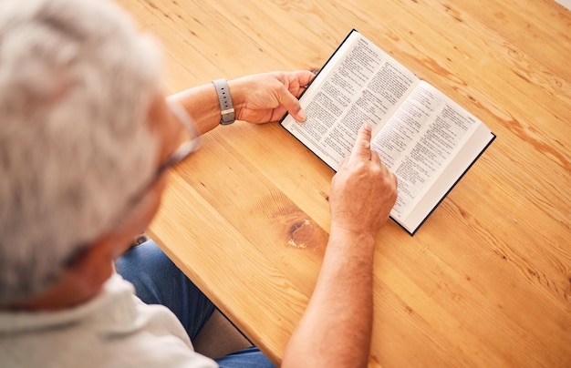 Powyżej czytania książki lub starca z świętą biblią do wsparcia kultu lub nadziei w chrześcijaństwie wiary na emeryturze Jezus Bóg lub starsza osoba studiująca lub ucząca się modlitwy ewangelii w religii duchowej