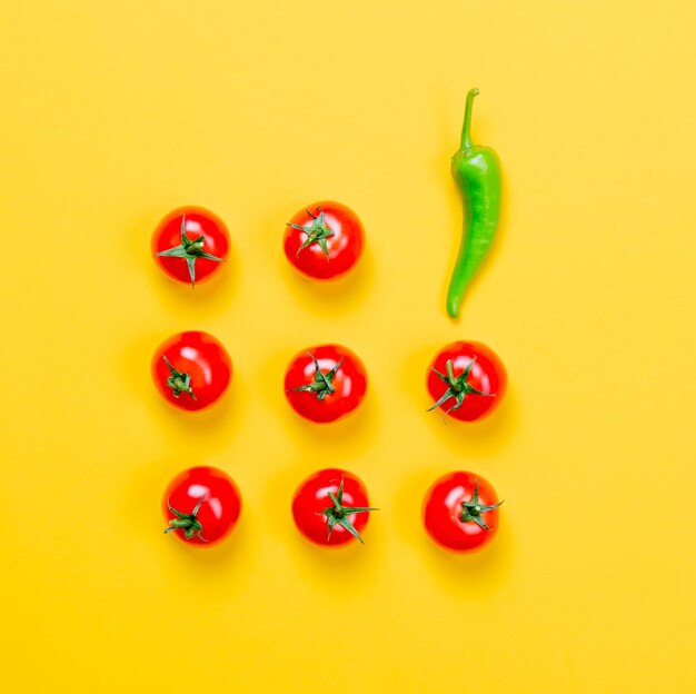 Powyżej widok na papryczkę chili i pomidory na żółtym tle
