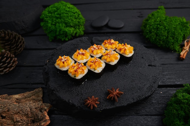 Powyżej widok różnych sushi i bułek umieszczonych na kamiennej desce japońskie jedzenie fest widok z góry płaskie lay