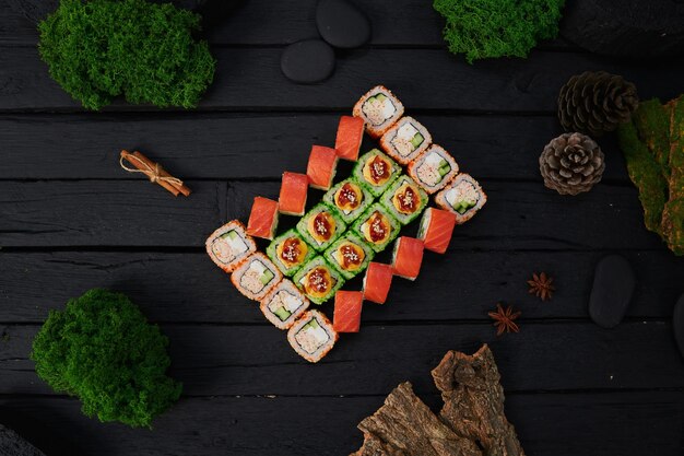 Powyżej widok różnych sushi i bułek umieszczonych na kamiennej desce japońskie jedzenie fest widok z góry płaskie lay