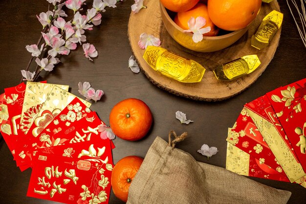 Powyżej zobacz akcesoria chińskiego nowego roku lub festiwalu Mood Day, złote pomarańcze i kieszenie Angpao z dekoracjami z gałęzi kwiatu wiśni.
