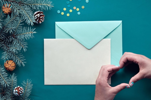 Pozdrowienia Ciepłe Życzenia na pocztówce z kopertą Ręce pokazują znak serca Tradycyjne Boże Narodzenie backgdrop