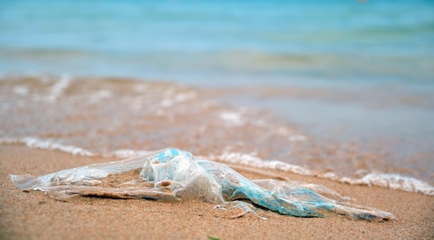 Pozostawiona plastikowa torba na śmieci na piaszczystej plaży Opróżnij używane brudne śmieci na brzegu morza Zanieczyszczenie środowiska Problem ekologiczny