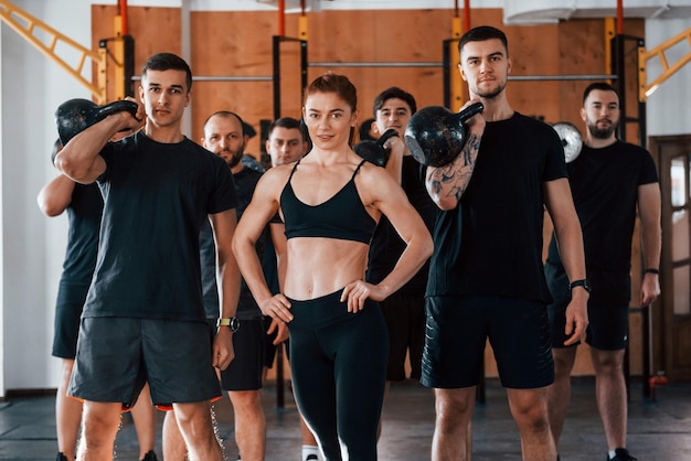 Pozowanie do kamery Grupa młodych sportowców ma dzień crossfitu w sali gimnastycznej