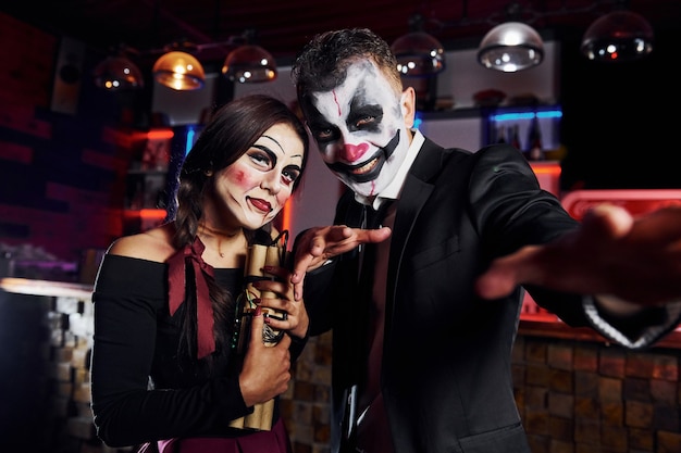 Pozowanie Do Kamery. Przyjaciele Są Na Tematycznym Przyjęciu Halloweenowym W Przerażających Makijażach I Kostiumach.