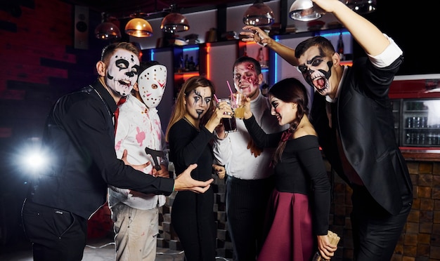 Pozowanie do kamery. Przyjaciele są na tematycznym przyjęciu halloweenowym w przerażających makijażach i kostiumach.