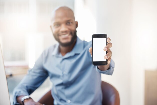 Pozwól, że zdobędę Twoje dane Przycięty portret przystojnego młodego biznesmena trzymającego telefon przy kamerze podczas siedzenia w biurze