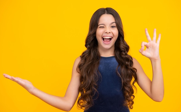 Zdjęcie pozytywne dziecko nastolatka wskazuje na bok z wesołym wyrazem twarzy, pokazuje niesamowite puste puste miejsce reklama i makieta podekscytowana twarz wesołe emocje nastolatki