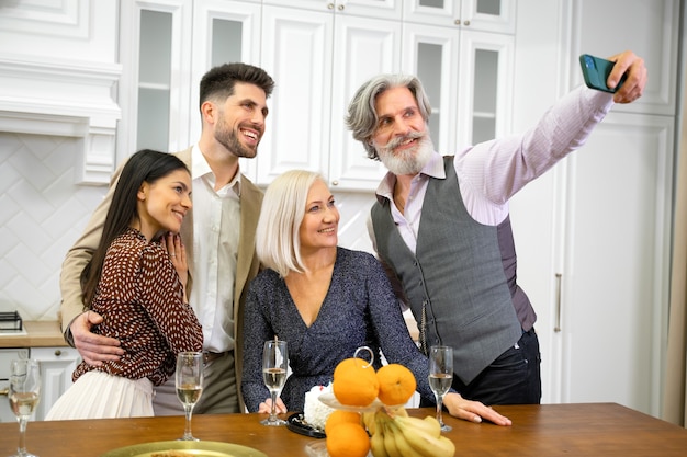 Pozytywni Rodzice I Młoda Para W Formalnym Stroju Robią Sobie Selfie Lub Nawiązują Wideorozmowę Na Smartfonie