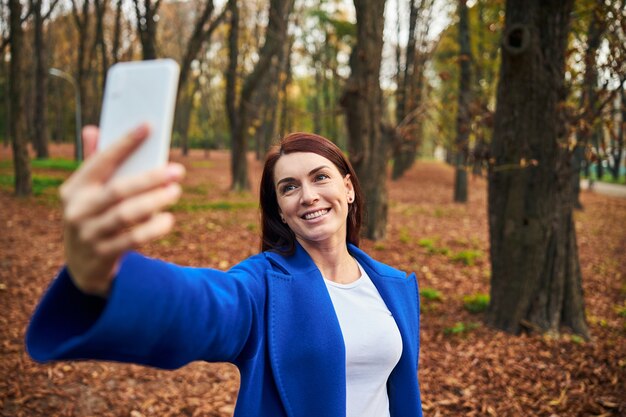 Pozytywnie zachwycona kobieta robiąca zdjęcie selfie