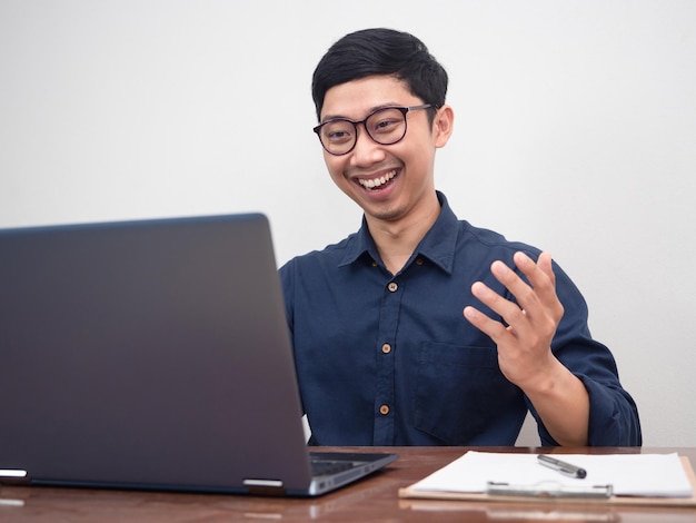 Pozytywny biznesmen nosi okulary zadowolony z pracy przy użyciu laptopa przy stole w miejscu pracy
