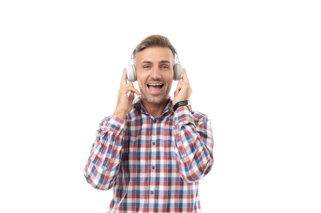 Pozytywny człowiek słucha muzyki w studiu Mężczyzna słucha muzyki i jest ubrany w kraciastą koszulę