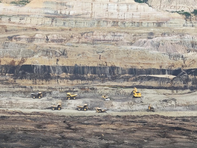 Praca ciężarówek i koparki w kopalni otwartej przy wydobyciu złota