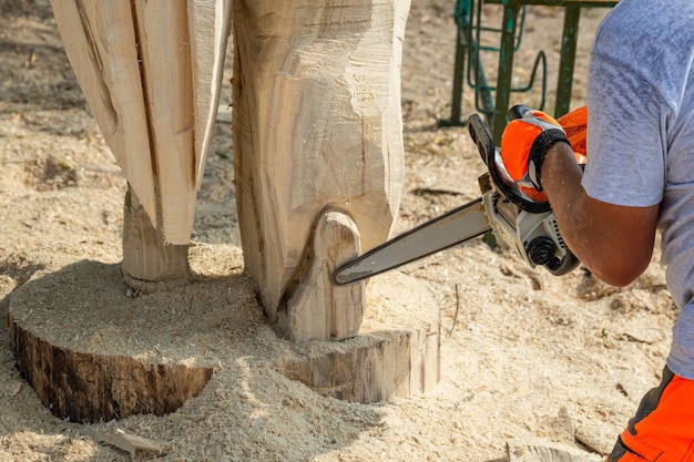Praca piłą łańcuchową na drewnie Rzeźby w drewnie Piłowanie drewna opałowego