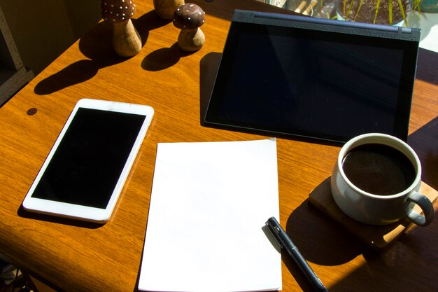 Zdjęcie praca w biurze z notebookem i telefonem komórkowym kawa i rośliny miejsce pracy