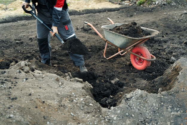 Praca Z łopatą I Taczką Do Narzędzi Ogrodniczych Na Terenie Przygotowań Do Wiejskiego Domu