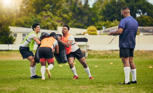 Praca zespołowa rugby i mężczyźni trenujący na boisku ze sprzętem gotowym do ćwiczeń meczowych i gier sportowych Zawody fitness i torba sportowa dla sportowców płci męskiej do rozgrzewki i treningu z trenerem