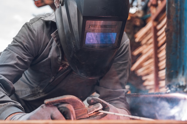 Zdjęcie prace spawalnicze, man welding in workshop. metaloplastyka i iskry. konstrukcja i koncepcja przemysłowa.