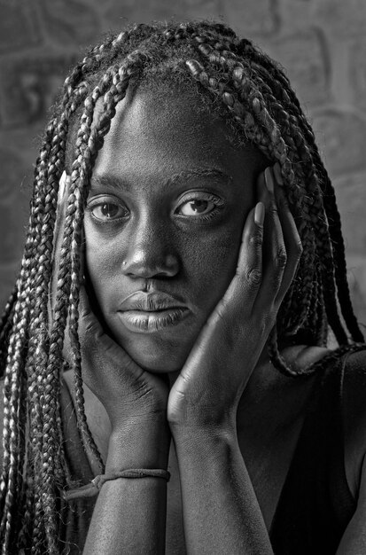 Zdjęcie pracowniany portret młodej czarnej kobiety z warkoczami