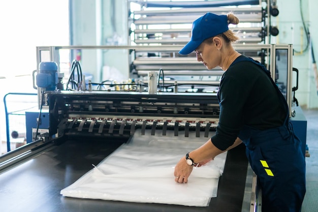 Zdjęcie pracownica przy produkcji opakowań z tworzyw sztucznych składa gotowe produkty