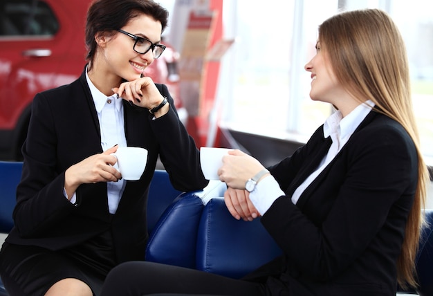 Pracownicy biurowi w przerwie na kawę, kobieta ciesząca się rozmową ze współpracownikami, uśmiechnięta