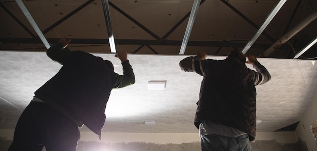 Pracownicy budowlani montujący sufit podwieszany