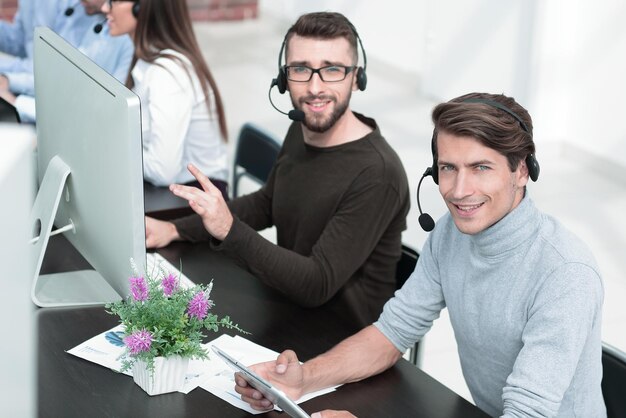 Pracownicy centrum biznesowego z zestawem słuchawkowym w miejscu pracy ludzie i technologia