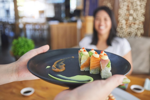 Pracownicy restauracji sushi i kelnerzy obsługujący naczynia z jedzeniem lub produkty z ryb dla klienta kawiarni lub sklepu Startup mały serwer biznesowy i osoba z bliskim zasięgiem z posiłkiem obiadowym dla klienta