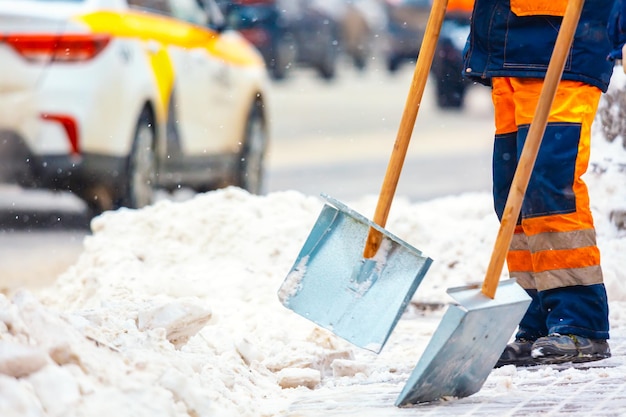Pracownicy służb komunalnych zamiatają śnieg z dróg zimą, sprzątają ulice miasta i drogi podczas śnieżycy. Moskwa, Rosja.