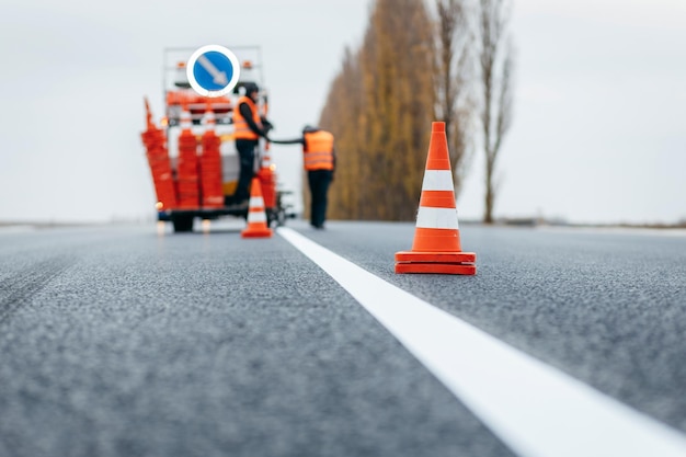 Pracownicy stosujący nowe oznakowanie dróg poza miastem