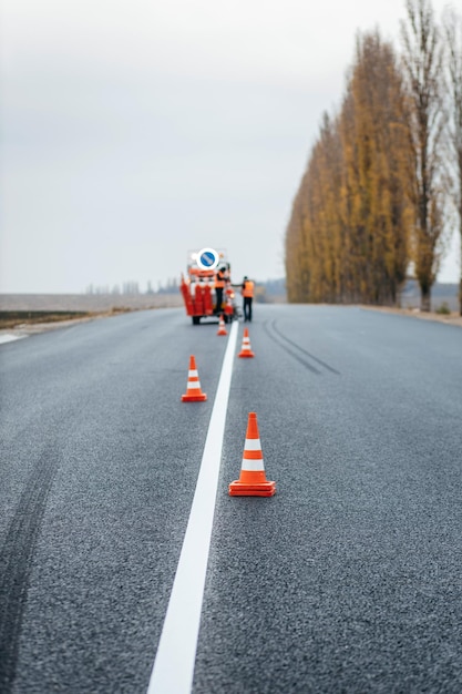 Pracownicy stosujący nowe oznakowanie dróg poza miastem