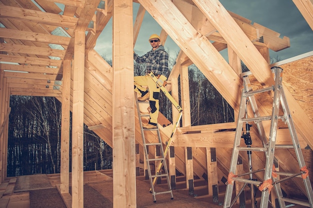 Zdjęcie pracownik budowlany budowa drewnianego domu rama