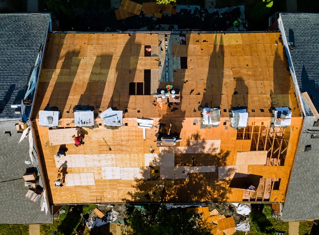 Pracownik budowlany na dachu gontów zastępczych dom zainstalował nowe gonty