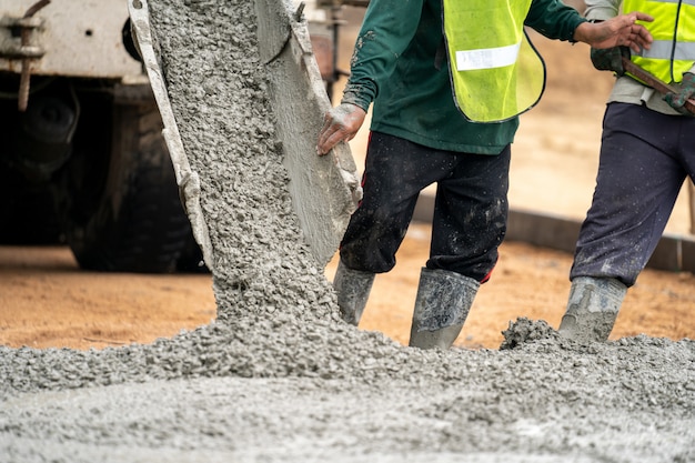 Pracownik Budowlany Wylewa Mokry Beton Na Budowie Drogi