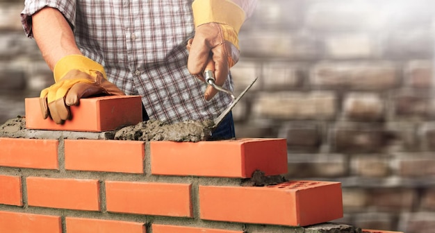 Pracownik buduje ceglany mur w domu