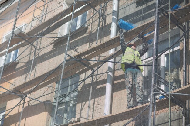 Pracownik na rusztowaniu na budynku w mieście.