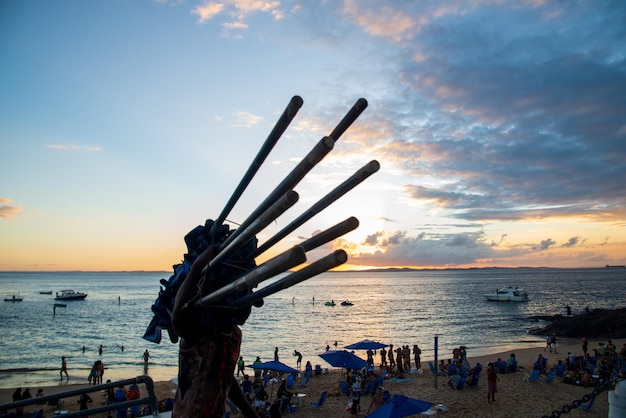 Pracownik plażowy nosi parasole na plaży Porto da Barra w mieście Salvador Bahia