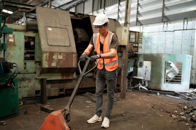 Zdjęcie pracownik przemysłu metalowego w fabryce w odzieży roboczej