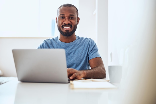 Pracownik rasy mieszanej korzystający z pracy na laptopie