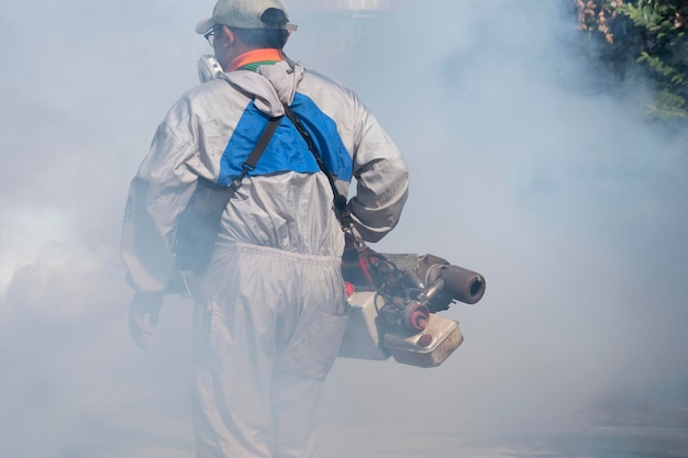 Pracownik Służby Zdrowia Na Zewnątrz Rozpyla środek Chemiczny W Celu Wyeliminowania Komarów W środku Oparów Chemicznych